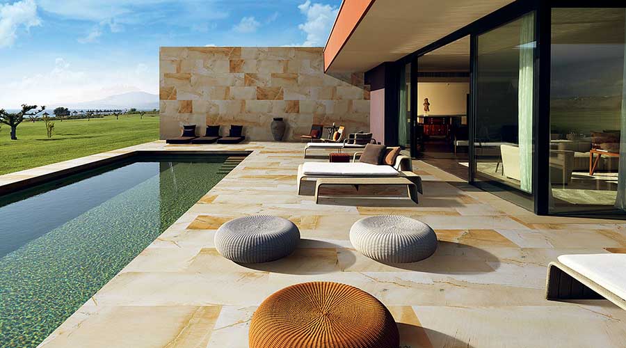 Sandstone effect thin porcelain tiles have been used for the patio and swimming pool of this stunning modern home