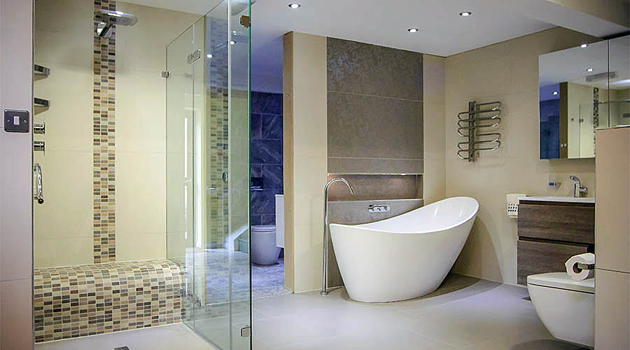 A large frameless glass shower enclosure with wetroom floor and tiled shower seat at the Room H2o bathroom showroom in Dorset