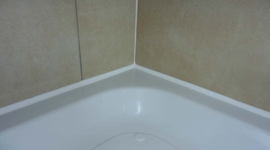 Tiles correctly sealed to the shower tray with silicone sealant