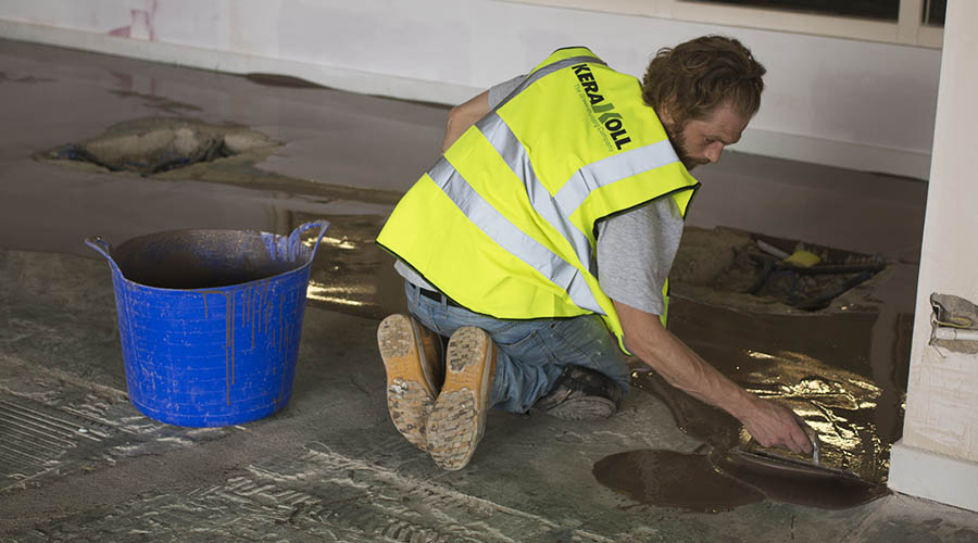 A UK Tiles Direct tiler appling Kerakoll Keratech R10 self leveling compound to the floors of the Yeomans Nissan showroom in Worthing