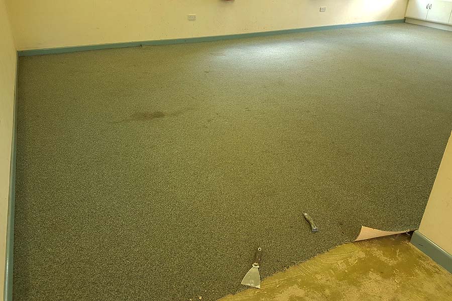 Removing the stained and worn carpet at Wareham village hall ready for new Karndean wood effect vinyl flooring 
